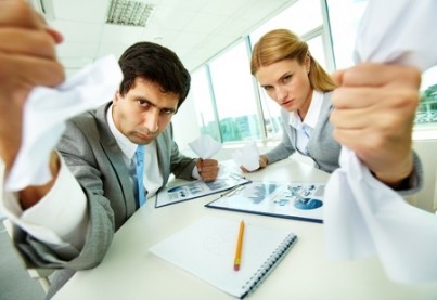 Portrait of angry employees with papers in hands looking at camera strictly